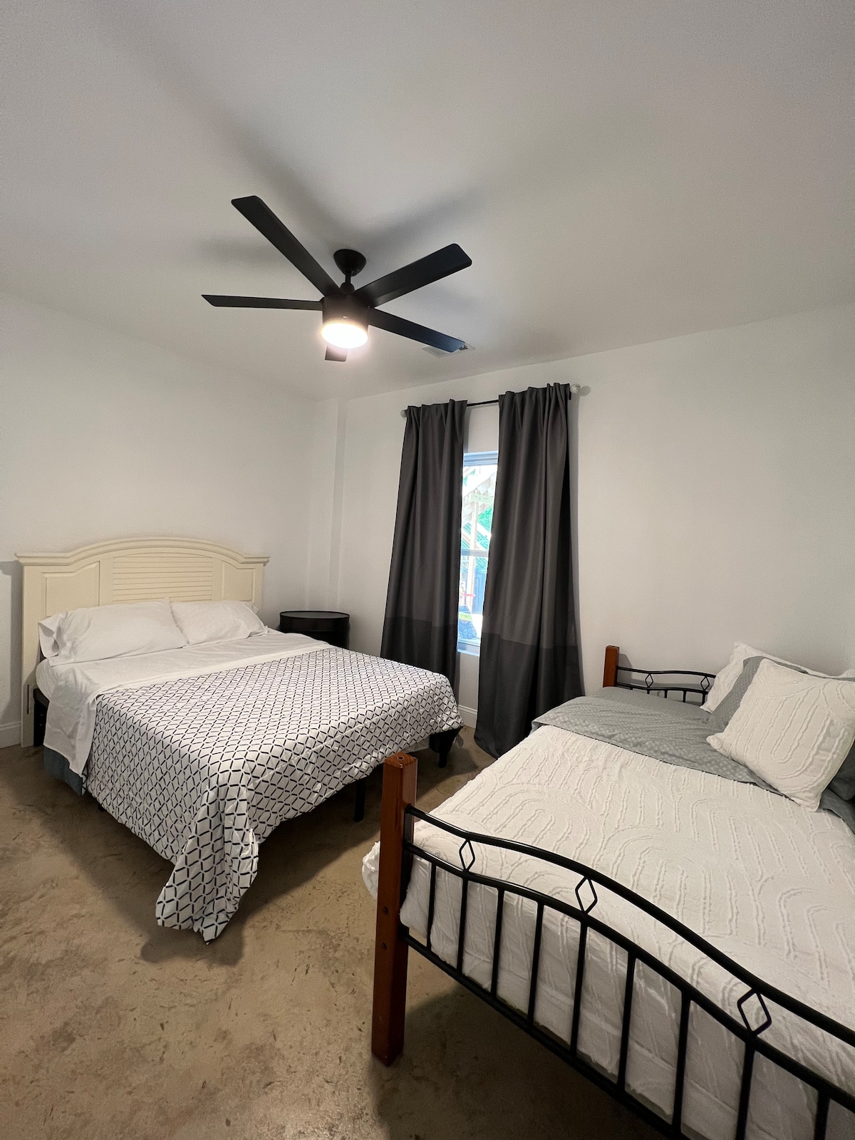 Una de las habitaciones en la planta baja con una cama tamaño queen y una individual