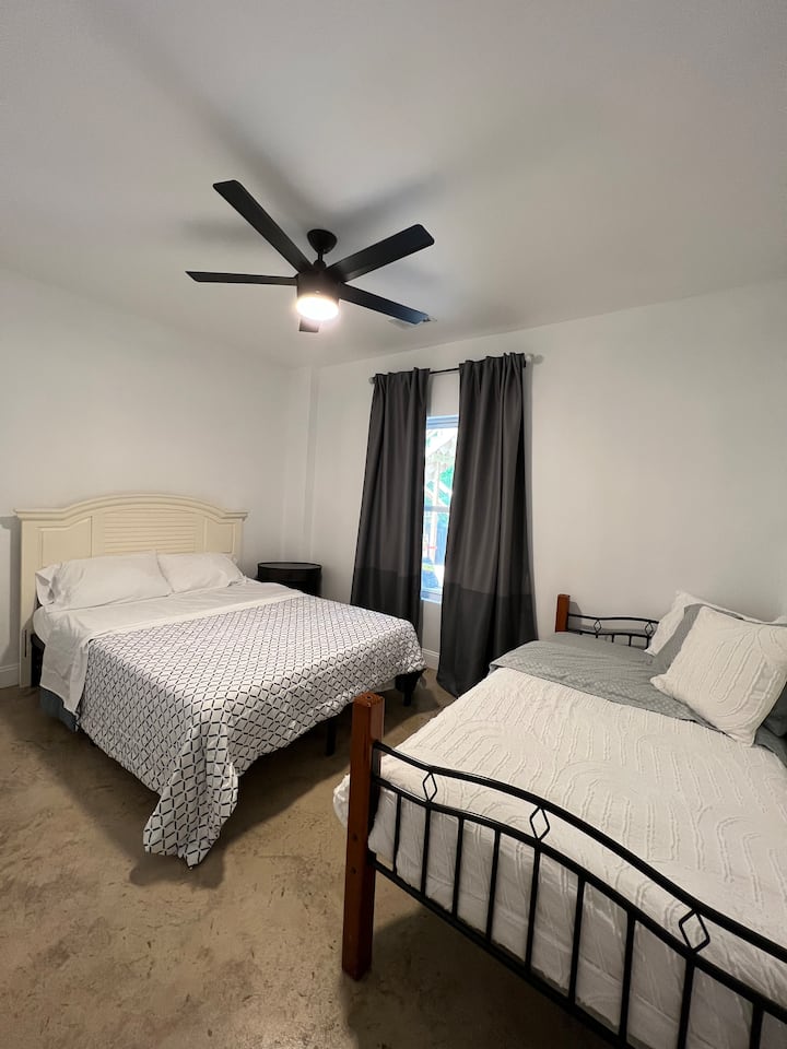 Una de las habitaciones en la planta baja con una cama tamaño queen y una individual