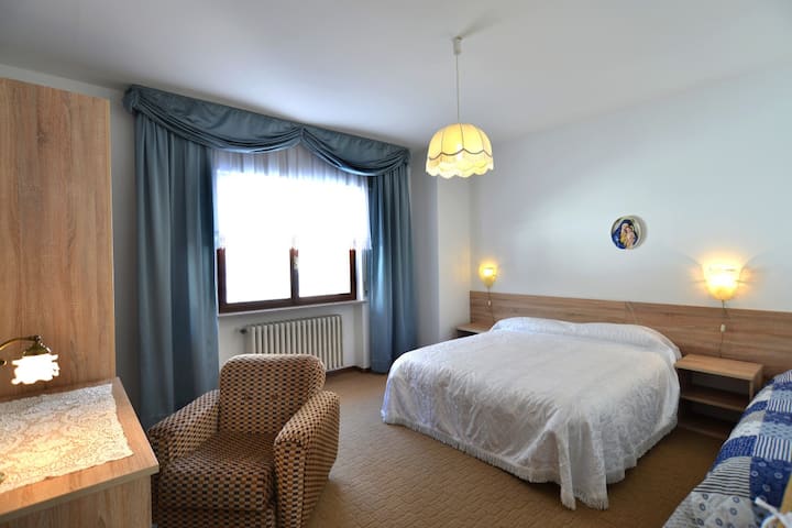 Спална соба со три кревета и детско креветче