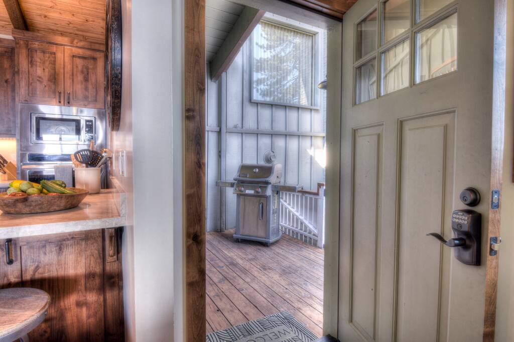 Front door with BBQ and deck access around the corner