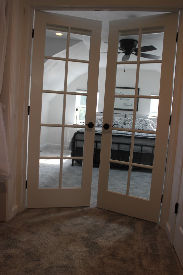 French doors provide privacy to the master bedroom with attached cordless blinds.
