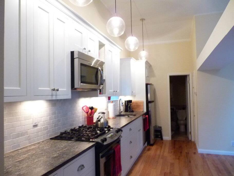 Kitchen is stocked with pans, plates, glassware, coffee maker, etc.
