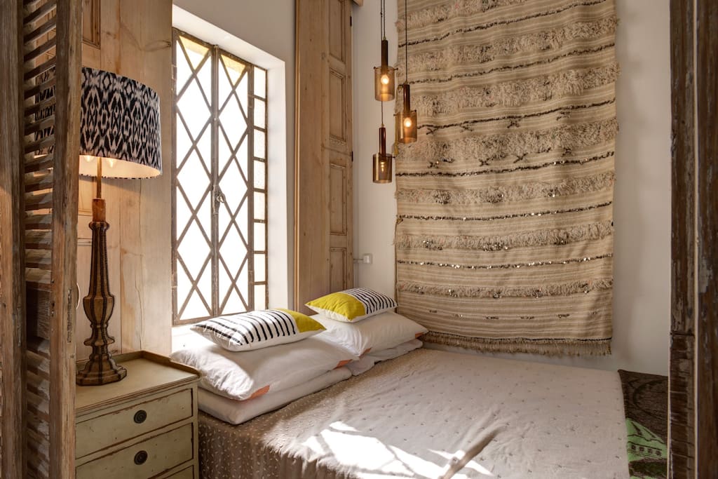 Comfy double bed with Moroccan wedding blanket hanging behind & church window for an intimate and elegant night's sleep!