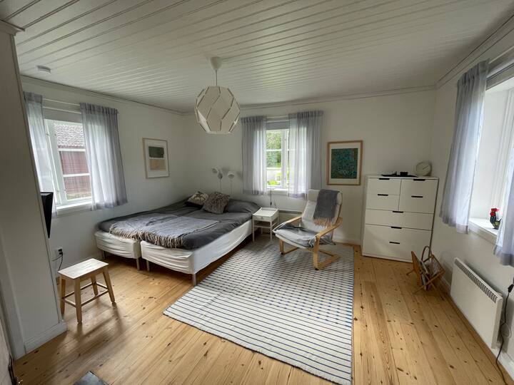 Dormitorio en la planta baja. Dos camas o cama doble. Posibilidad de instalar el colchón/cuna. Televisión en la pared, sillón, armario y vestidor.