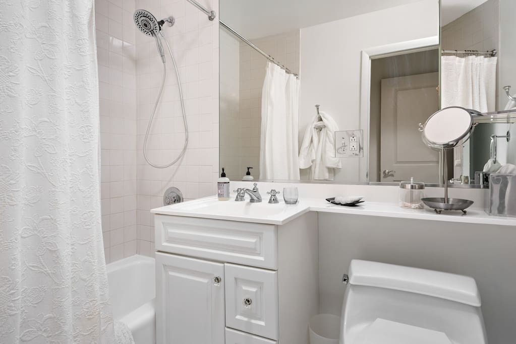 All white bathroom with tub and shower.