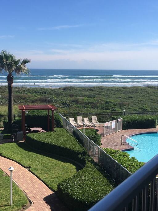 Balcony view: manicured lawn, grill, lanai, hot tub, heated swimming pool, Gulf