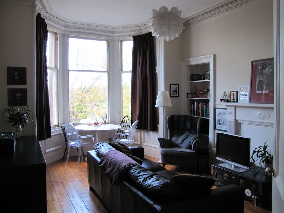 Living room with high ceilings and wooden floor.