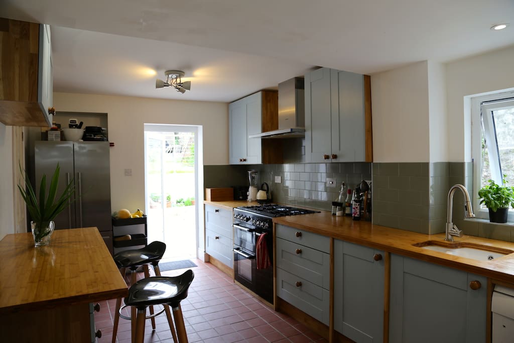 Kitchen with breakfast bar, gas range, large fridge freezer, dishwashing machine. Direct access to back garden.