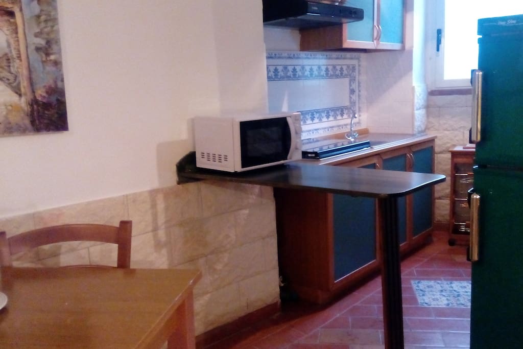 cucina con accessori frigo microonde posate piatti pentolame vario tavolo