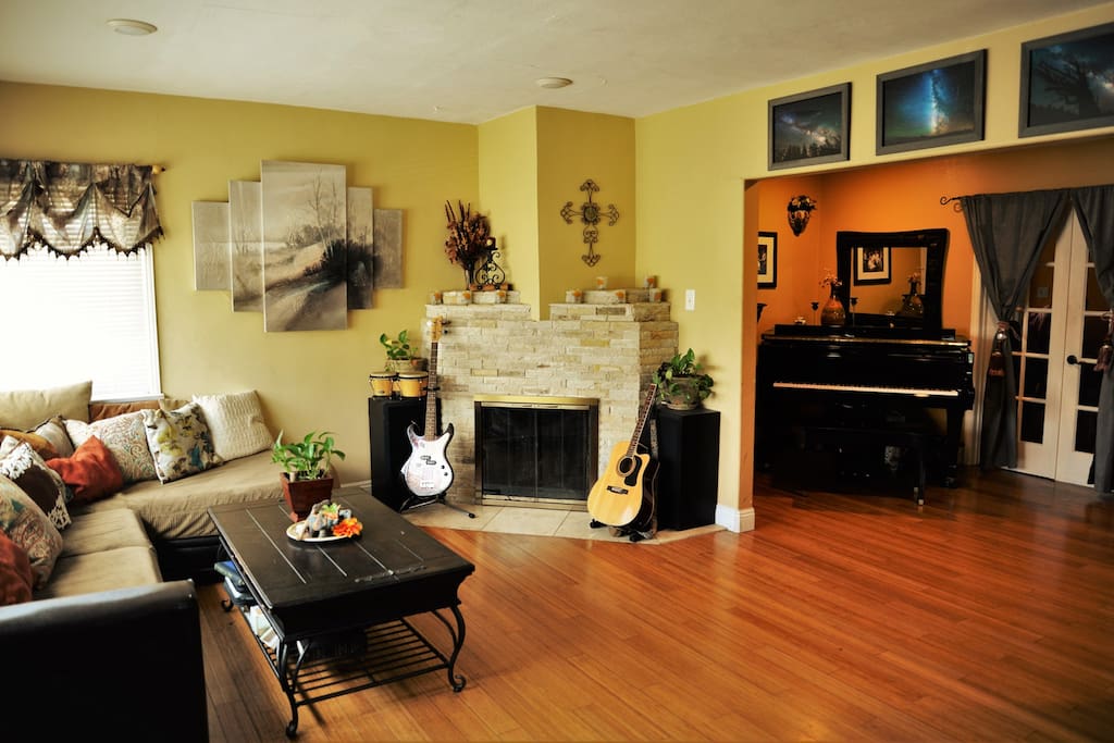 Bright, airy common space includes sectional sofa, fireplace and grand piano