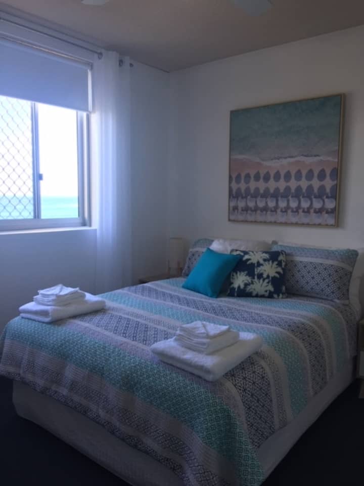 Dormitorio 1: una cómoda cama tamaño queen, mucho almacenamiento, vistas al mar y el sonido del surf rodando para relajarte y dormir.