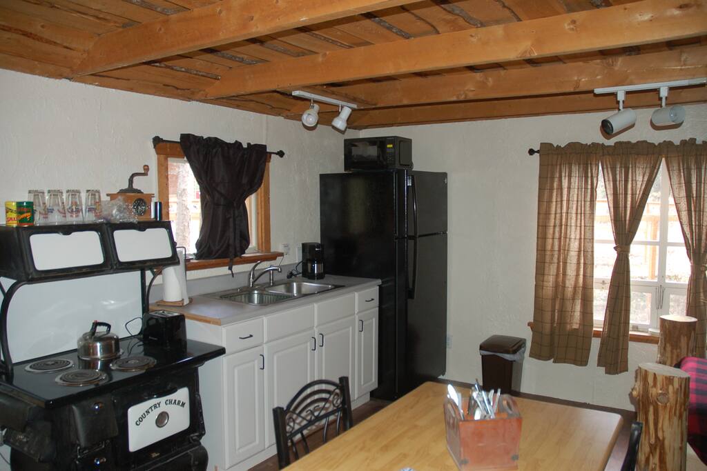 Tranquility Cabin Kitchenette with stove top, microwave, refrigerator and table for two