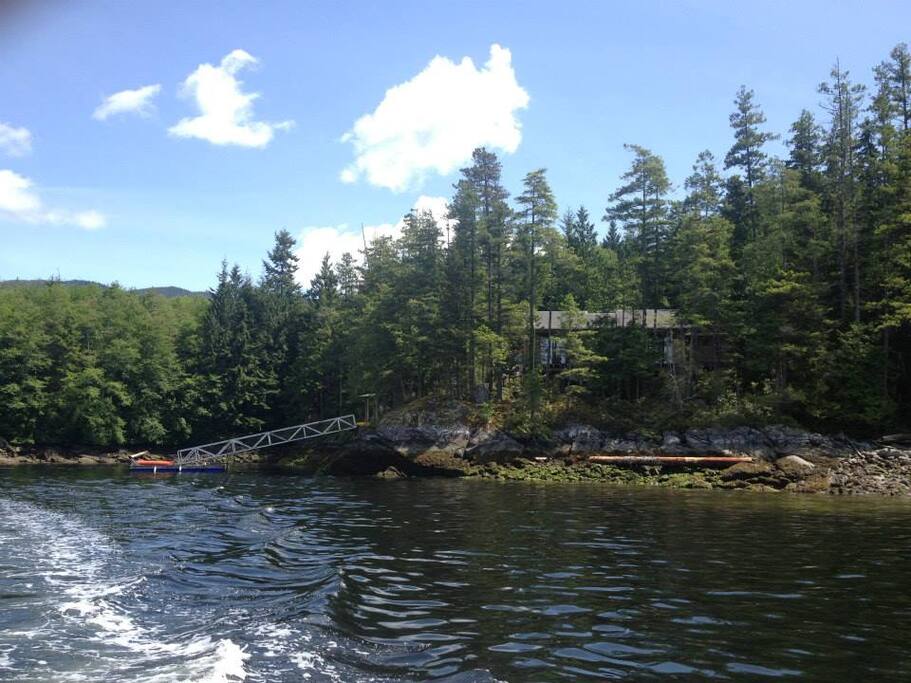 View from the water. Dock is on the left and rocky beach on the right.