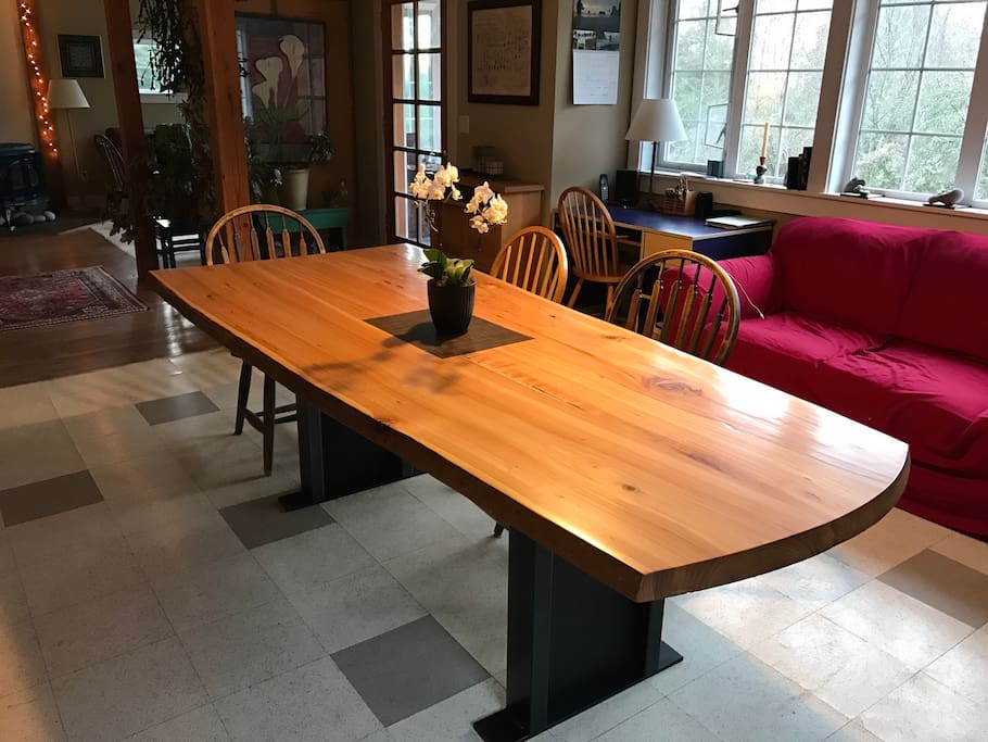 Live-edge cedar dining table in a light-filled common room