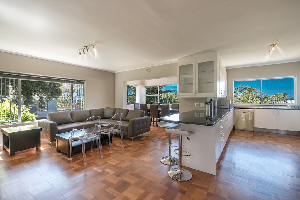 Open plan kitchen with bar counter onto lounge and dining