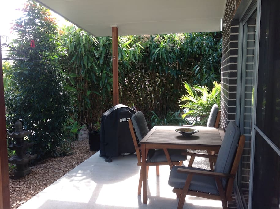 Covereded outdoor garden deck with timber table setting and new Webber BBQ . Outdoor shower just around the corner !
