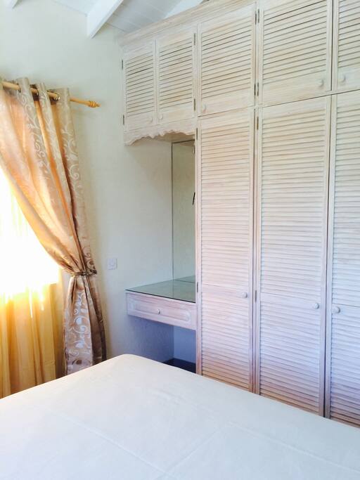 Bedroom with spacious vanity area and lots of storage space for clothing and suitcases.