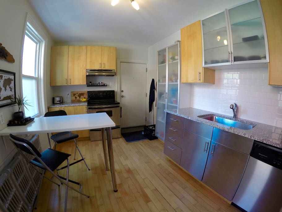 Kitchen with oven, toaster, microwave, dish washer, fridge and double sink. Includes back entrance from parking. Seating for 2 or 4 (additional seats not shown)