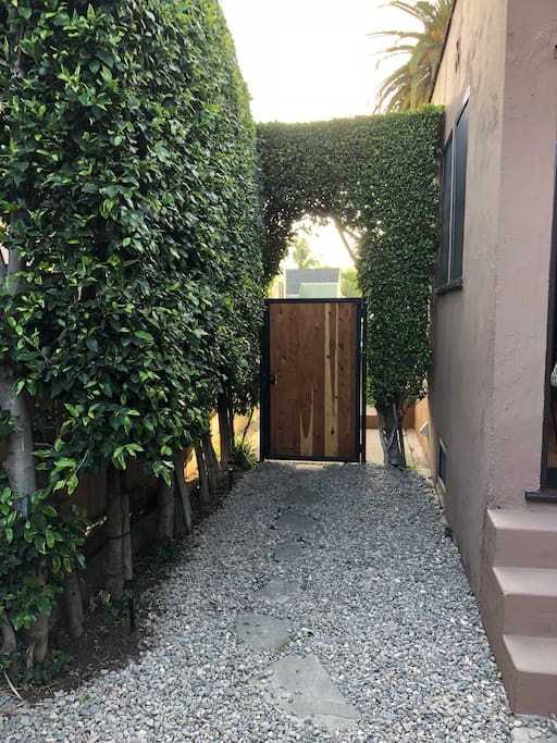 Beautiful hedge covered private entrance with craftsman wood style door and private gated entrance.