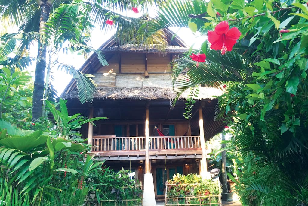 FAMILY SURF BUNGALOW (upstairs~above the Garden Triple Room ~Ideal for 6 persons) •Bedroom 6x6m2 •3 queen size beds with mosquito nets •Balcony 3x6m2, 2 hammocks and a table •Bathroom 2x3m2, western standard toilet, hot and cold shower, sink and mirror •Fan •In-room safety box •Writing desk •TV local channels •Breakfast for 6 persons