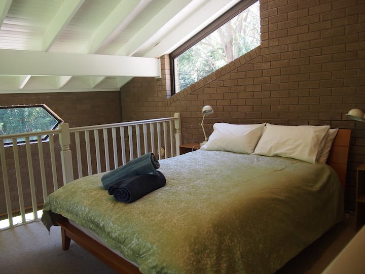 غرفة نوم علوية بسرير بحجم كبير فوق غرفة الألعاب