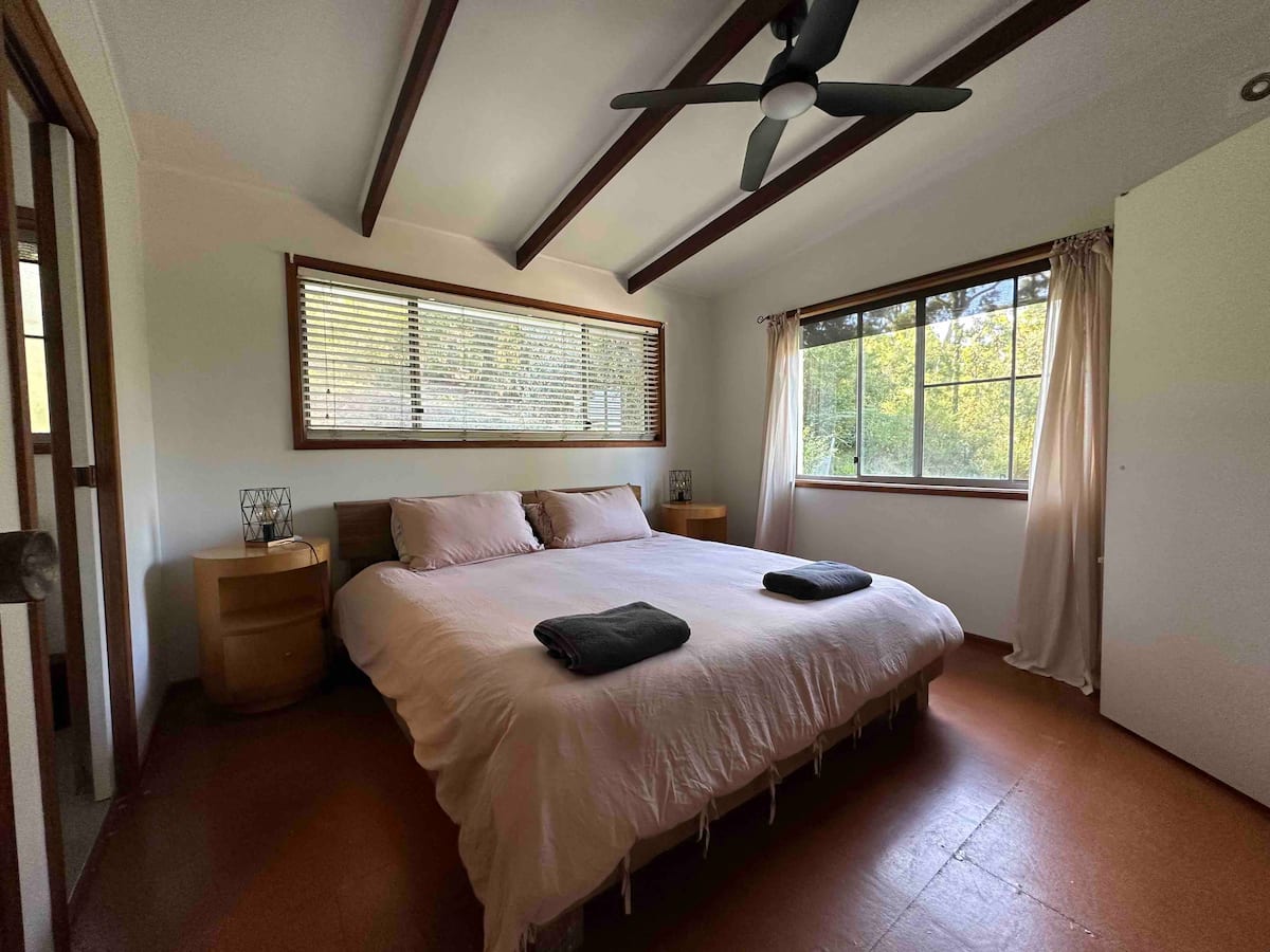 Master bedroom with king bed and ceiling fan