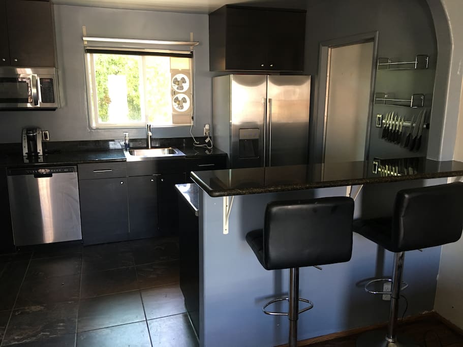 Kitchen with bar, gas range, microwave, dishwasher, refrigerator with-filtered water & ice & Keurig w/coffee, dishes/cookware and eating utensils.