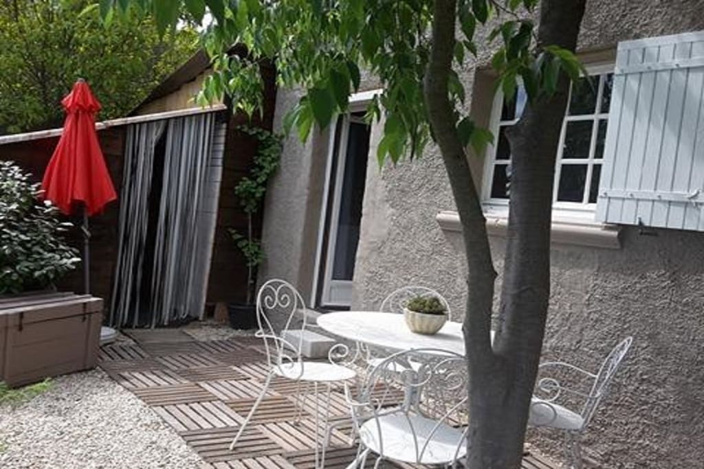 Terrasse privée ombragée ,devant le studio, avec salon de jardin et barbecue à gaz.