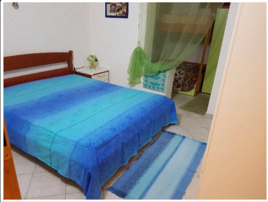 Letto matrimoniale e letto a castello dietro la tenda