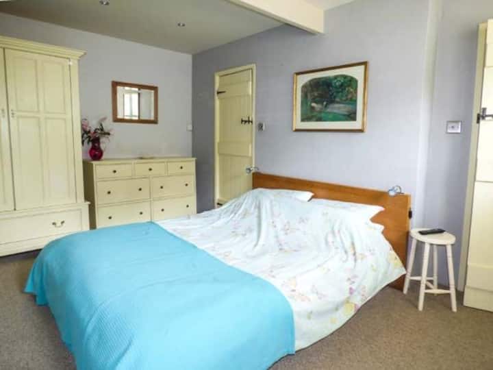 Chumba kikubwa cha kulala mara mbili na bafu ya chumbani na ukuta uliowekwa kwenye runinga