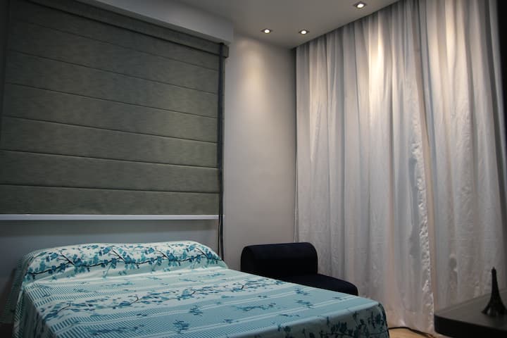 Dormitorio de los huéspedes con cortina romana.