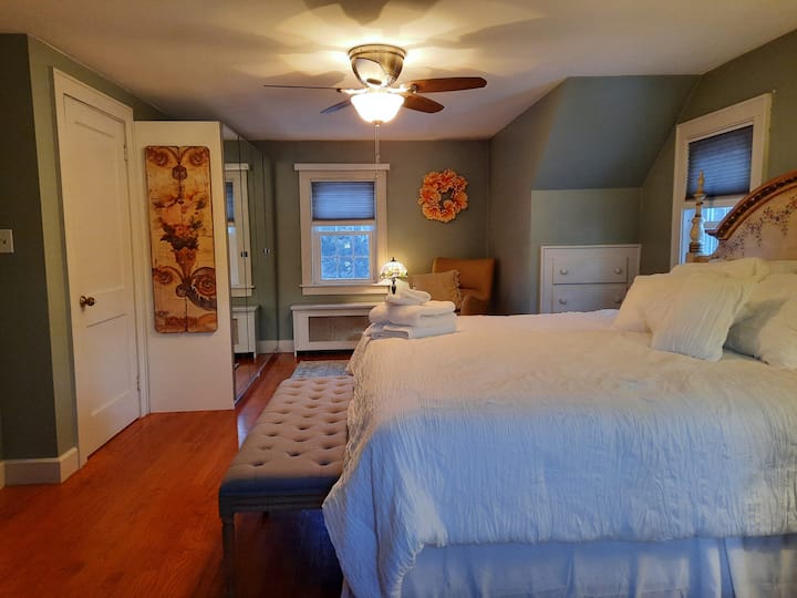 Ძირითადი საძინებელი ზემოთ. დიდი ზომის საწოლი, სამკითხველო სკამი და ბევრი კარადა.