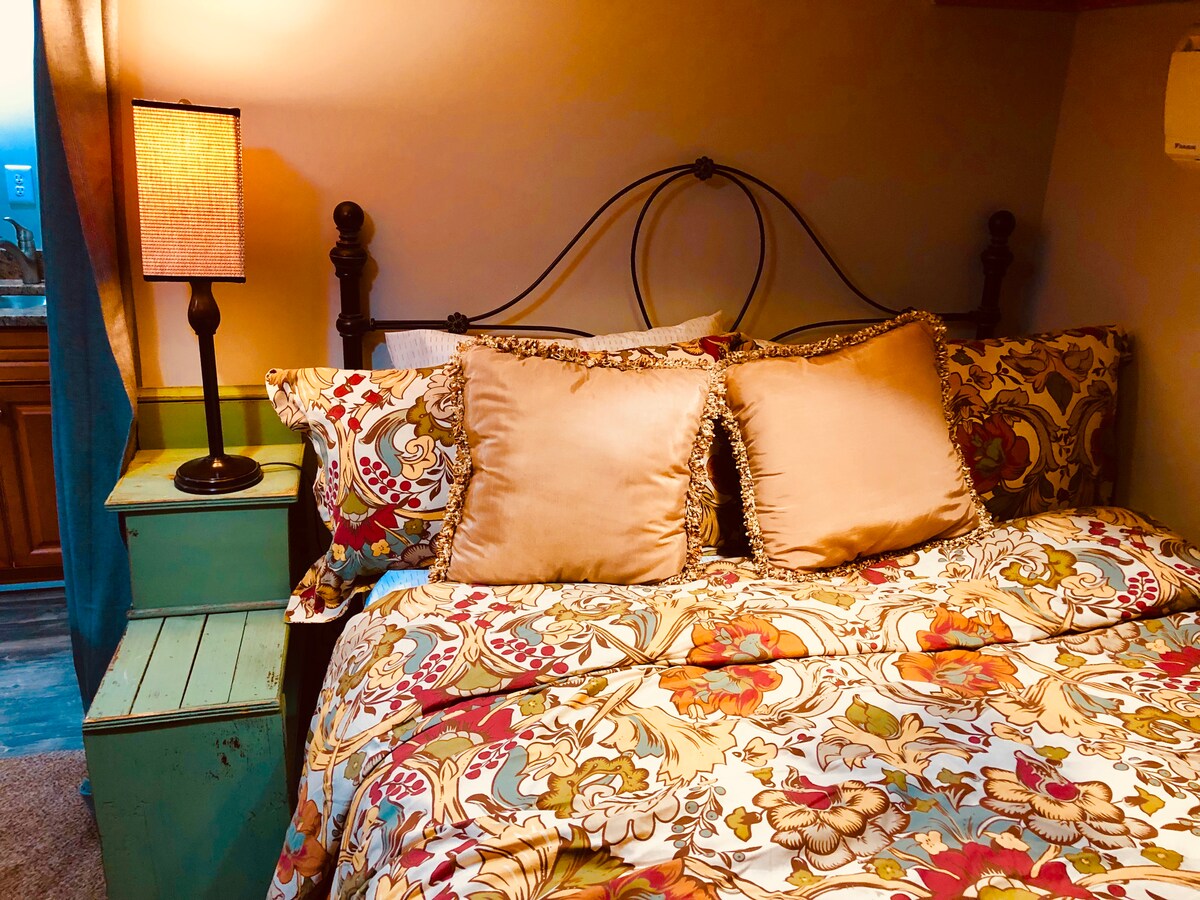 אזור חדר שינה נעים עם כרבולית וכריות נוספות. יש גם מתלה לתליית בגדים. 