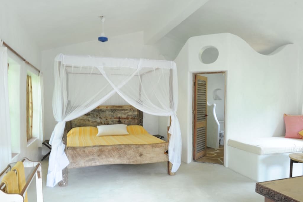Spacious bedroom with king size double bed, comfortable mattress, cotton sheets and mosquito netting on windows and bed