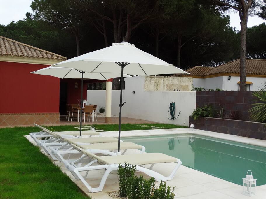 Zwembad met ligstoelen en parasols