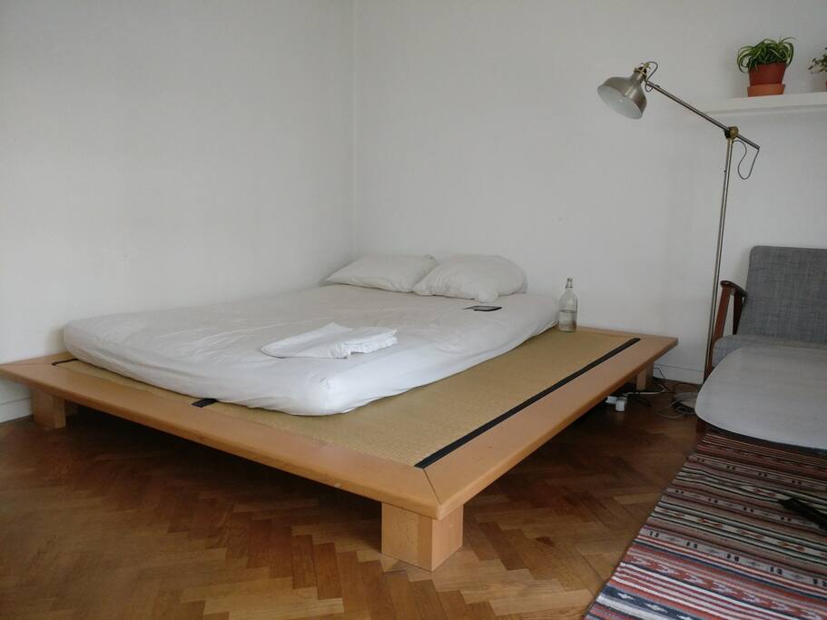 It's a queen sized bed - the edge is used as a bench alongside the table