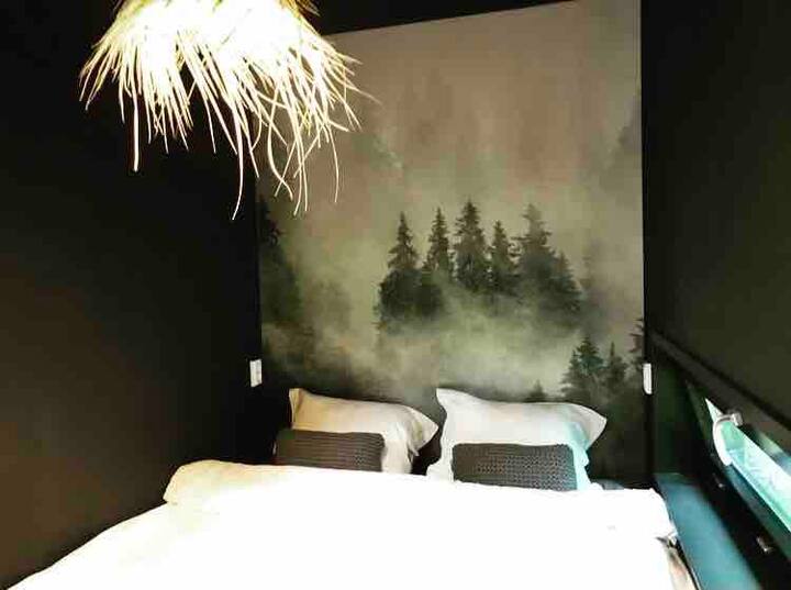 De kleine slaapkamer biedt een bedsteegevoel met een bed van muur tot muur (180 x 200) en een grote kledingkast