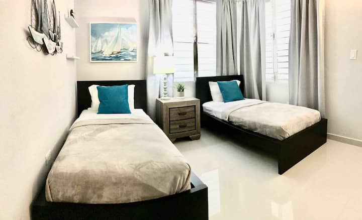 Our elegantly designed, air-conditioned bedroom features two twin beds, offering both comfort and ample space. 