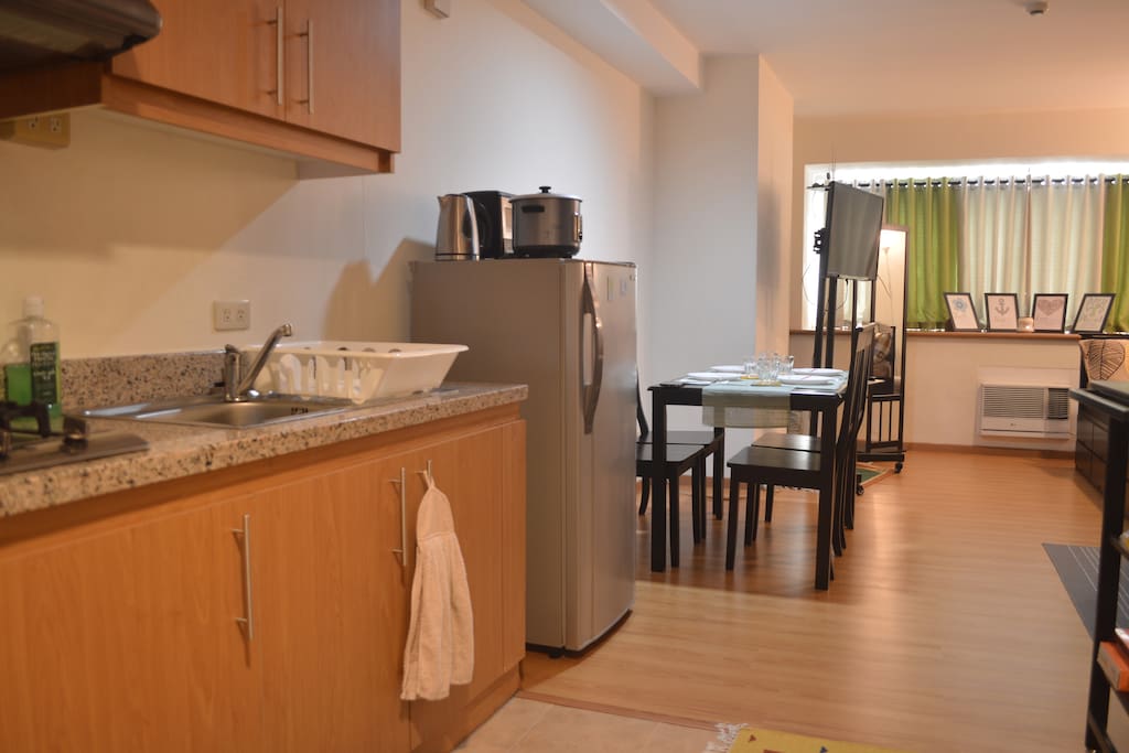 From this view, you can see our kitchen sink (cleaning supplies are under the sink), cupboards (cookware, cooking utensils and dinnerware are in the overhead cabinets), fridge and dining area.