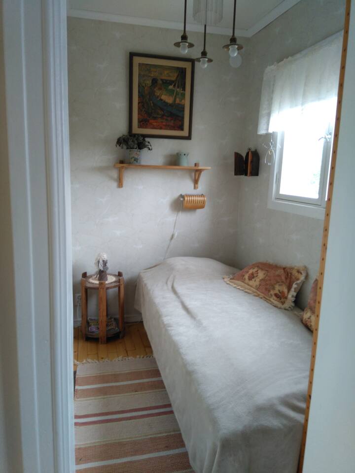 Pequena alcova de dormir com cama de solteiro.
