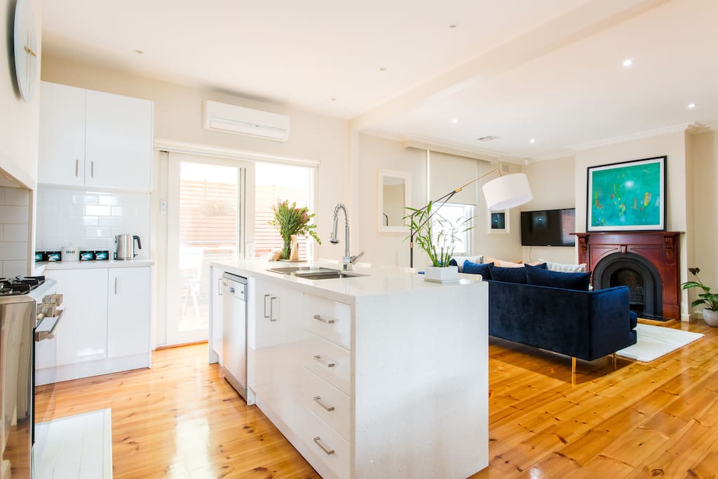 The kitchen and living room with its grand fireplace. The 50" flat screen TV is connected to Netflix for guests to enjoy at no extra cost.