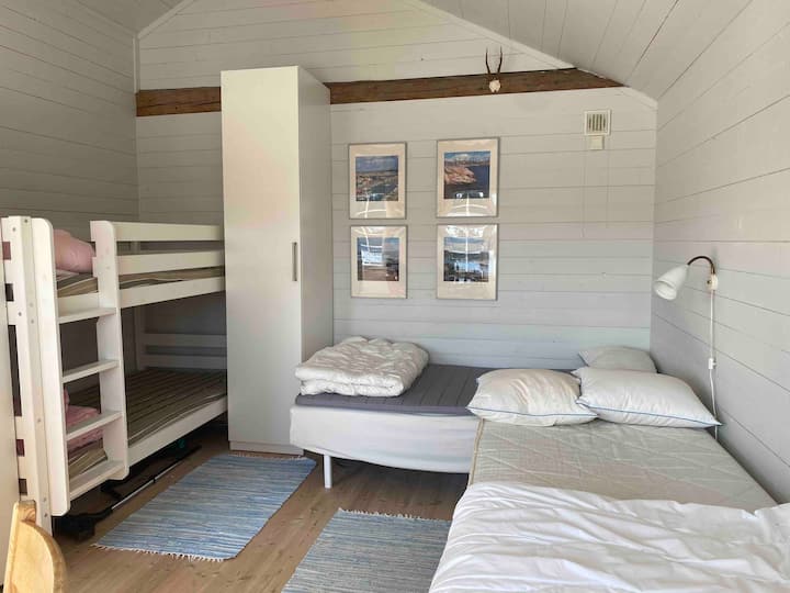 ゲストハウスの寝室。シングルベッド2台、二段ベッド1つ。 毛布と枕が用意されています。 ベッドは、到着時にシーツ、羽毛布団カバー、枕カバーで作られています。 