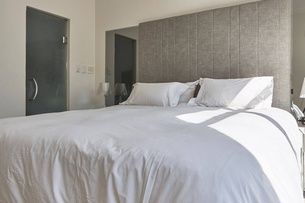 Master bed with view of door to en-suite bathroom.
