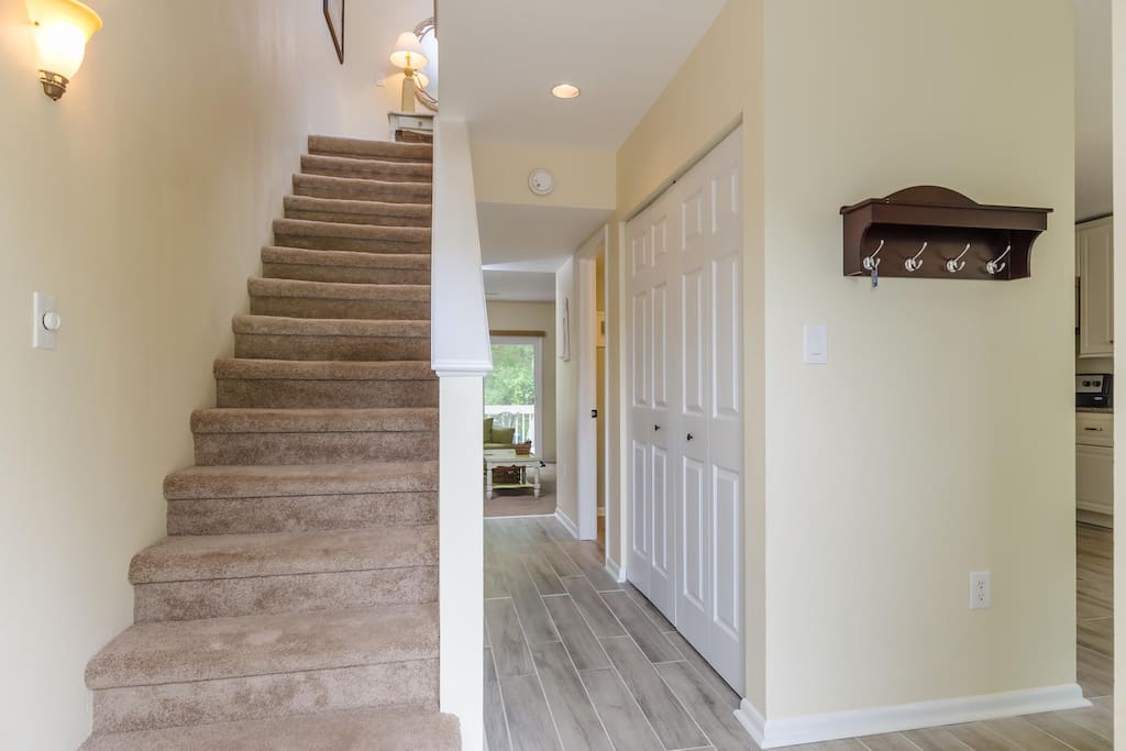 Spacious entryway leading to laundry closet and living room beyond