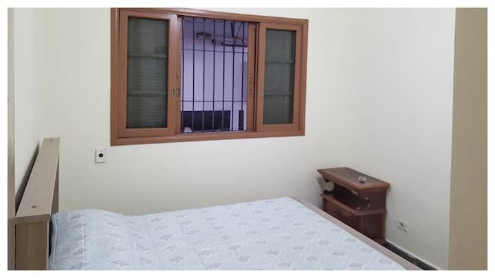 ห้องนอน 3 ของโถงทางเดินพร้อมพัดลมเพดานโต๊ะข้างเตียงและชั้นวางของ 