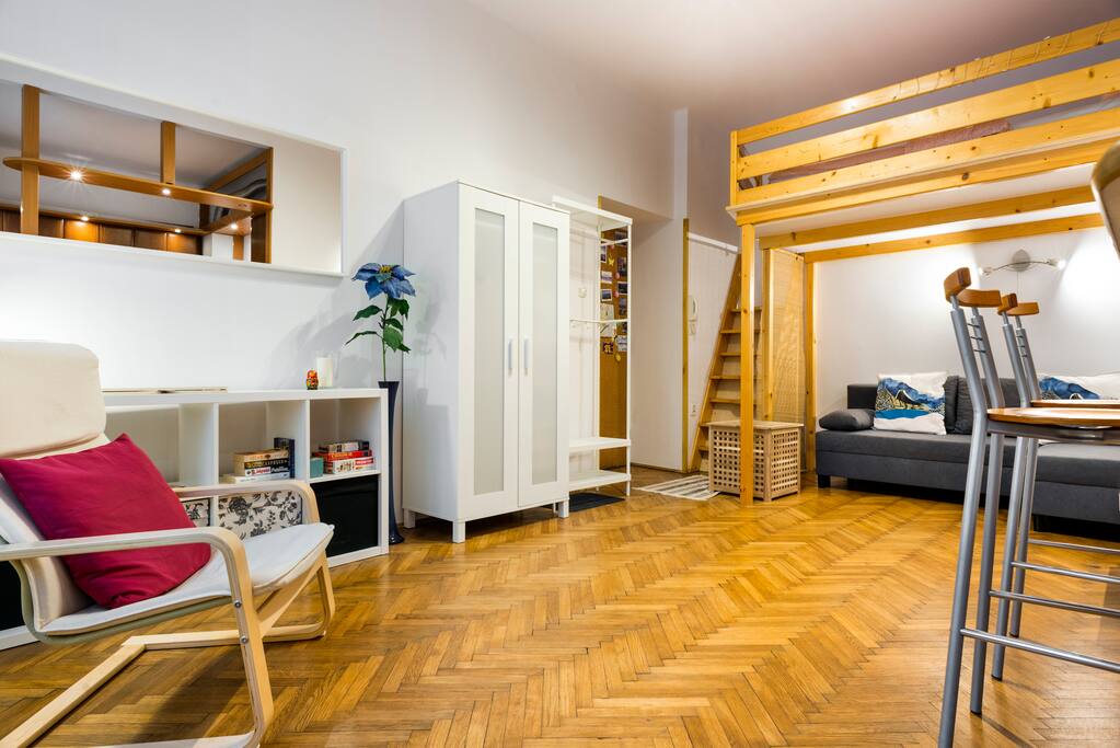 Cosy living room with sofa bed, armchair, wardrobe, TV and entresol bed