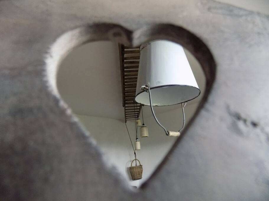 Ancienne échelle qui traverse la pièce de vie.
Elle soutient les différentes petites lampes qui égaille l'espace.