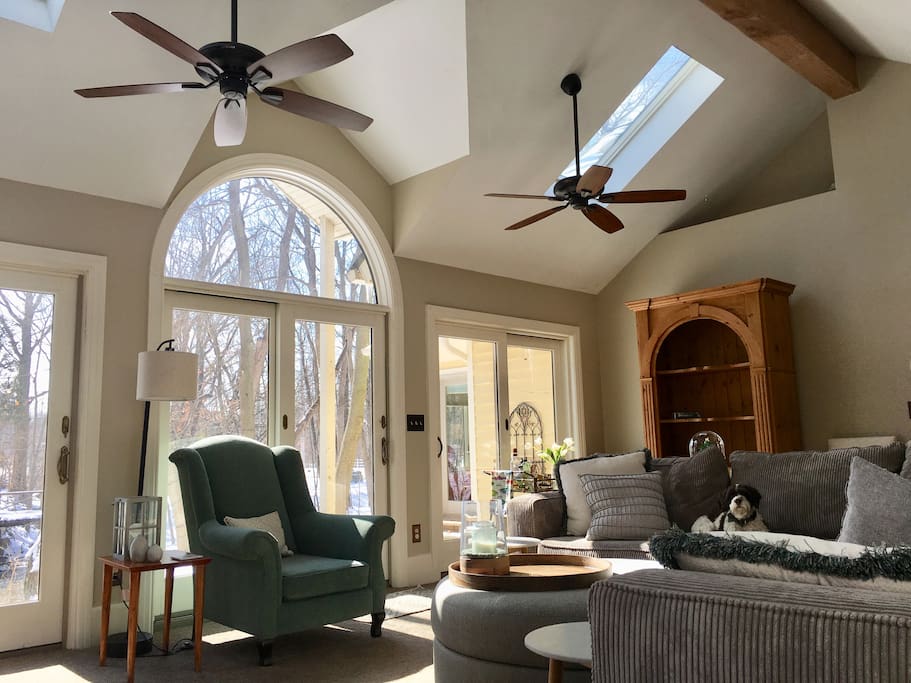 The great room with three sets of sliding doors. The center doors go out to a slate patio overlooking the creek. The armoire contains cards and board games for your family members to enjoy.