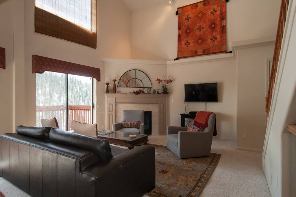 Elegant living room with cathedral ceiling and view of the Diamond Pick Ski Runs