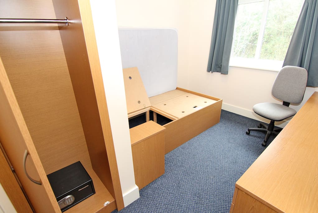 Standard 'Undressed' room with safe and storage. TV in communal living/kitchen area